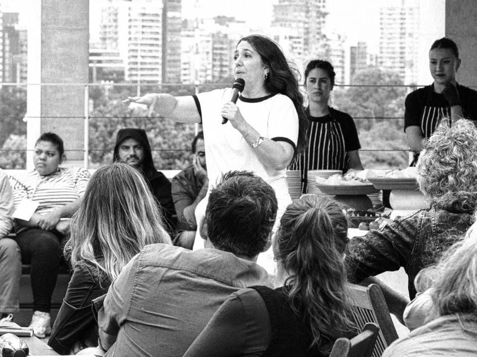 Ciclo de charlas de Pan y Pánico en una terraza, con el público escuchando