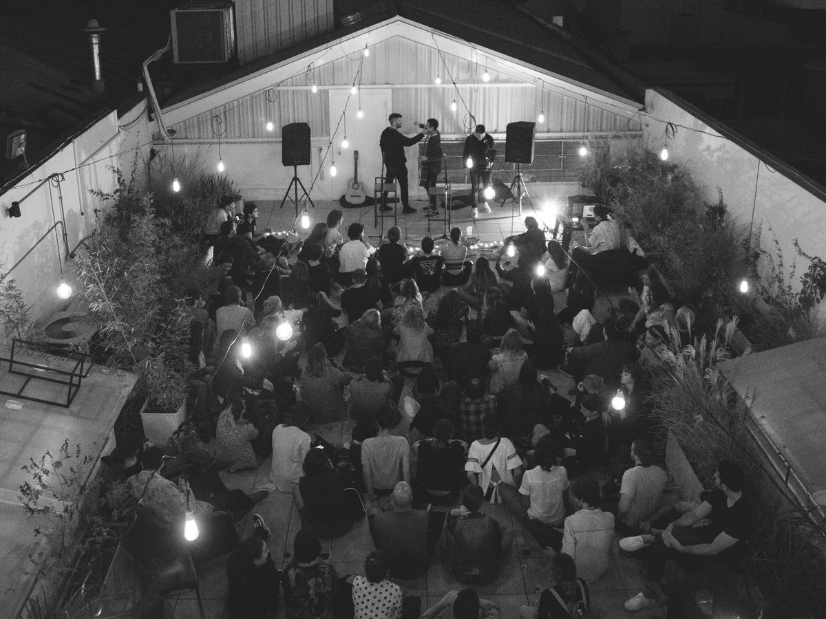 Show en una terraza con el público sentado alrededor del escenario